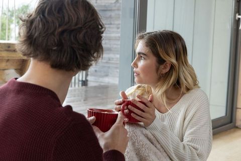 Cozy Couple Enjoying Warm Beverages at Home by Window