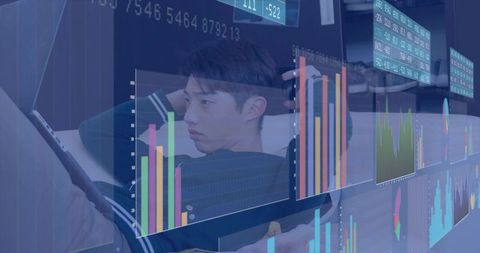 Korean teen reclining on sofa viewing tablet with futuristic finance dashboards overlaying
