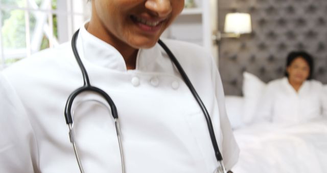 Nurse in uniform smiling while caring for patient in a hospital room. Suitable for illustrating concepts of healthcare, medical profession, patient care, hospital environment, nurse duties, and empathetic care in medical settings.