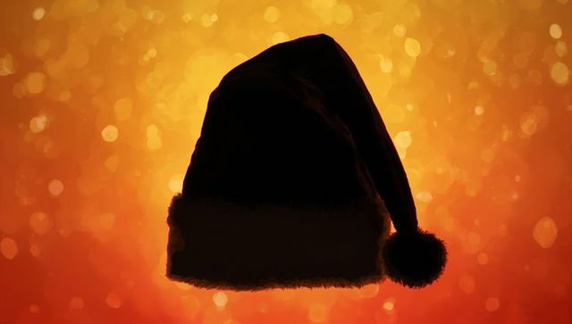Backlit santa hat silhouette with golden bokeh glow and rim-lit fuzzy trim