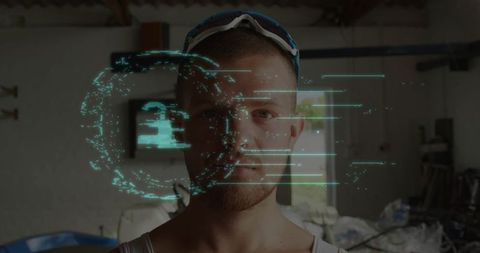 Young man wearing goggles in garage workshop with teal futuristic holographic hud