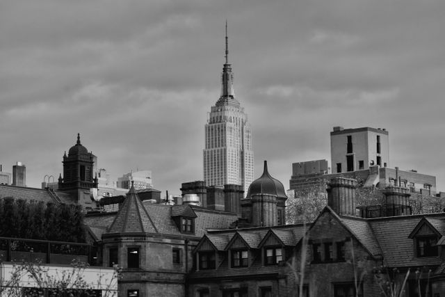 Depicting the iconic New York City skyline in black and white with the Empire State Building standing prominently among other buildings, ideal for decorating offices, homes, or blogs focusing on architecture, urban life, and New York City.