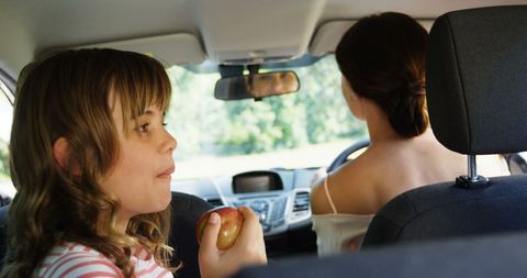 Child Enjoying Apple in Car Backseat with Woman Driver - Download Free Stock Images Pikwizard.com