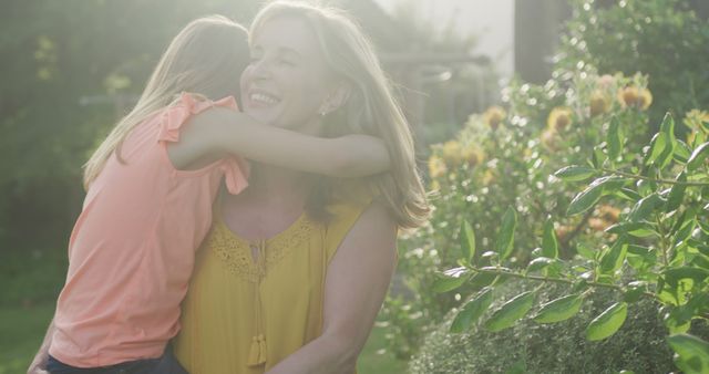 Joyful Mother and Daughter Embracing in Sunlit Garden - Download Free Stock Images Pikwizard.com