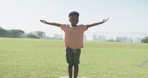 Young boy practicing balance outdoors with city skyline
