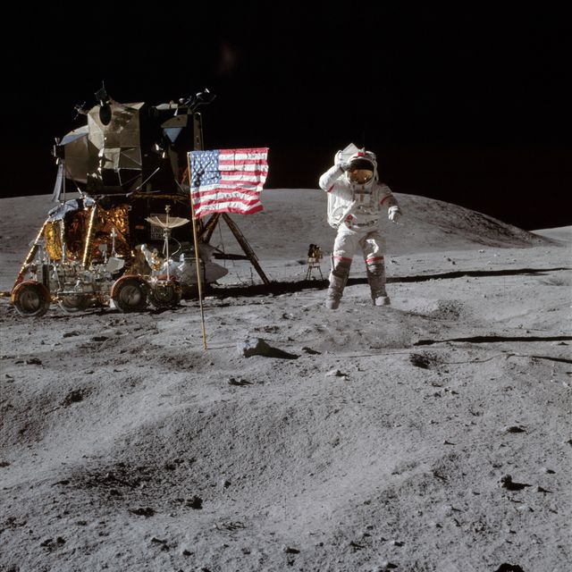 AS16-113-18339 (21 April 1972) --- Astronaut John W. Young, commander of the Apollo 16 lunar landing mission, leaps from the lunar surface as he salutes the United States flag at the Descartes landing site during the first Apollo 16 extravehicular activity (EVA).  Astronaut Charles M. Duke Jr., lunar module pilot, took this picture. The Lunar Module (LM) "Orion" is on the left. The Lunar Roving Vehicle (LRV) is parked beside the LM. The object behind Young (in the shade of the LM) is the Far Ultraviolet Camera/Spectrograph (FUC/S). Stone Mountain dominates the background in this lunar scene. While astronauts Young and Duke descended in the LM to explore the Descartes highlands landing site on the moon, astronaut Thomas K. Mattingly II, command module pilot, remained with the Command and Service Modules (CSM) "Casper" in lunar orbit.