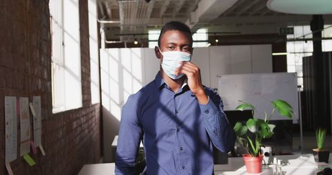 Confident Businessman Removing Mask in Modern Office - Download Free Stock Images Pikwizard.com