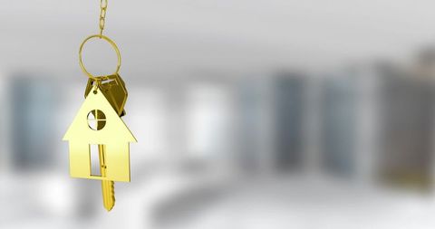 Golden house key against blurred background symbolizing real estate