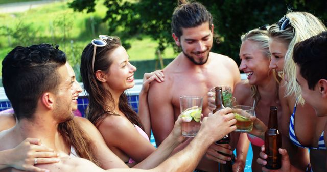 Group of young adults having fun at a pool party while enjoying drinks. Ideal for use in promoting summer events, outdoor activities, and social gatherings, emphasizing leisure and friendship.