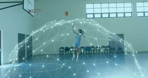 Leaping basketball player shooting through digital mesh dome in sunlit indoor court