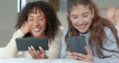 Diverse Friends Engaging with Smartphones in Cozy Bedroom