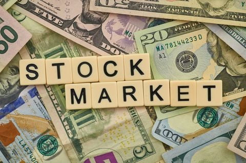 Stock Market Concept with Wooden Letters and Currency Background