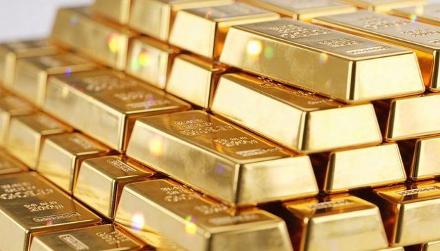 Stacked gold bars reflecting light and revealing purity stamps in luxury bullion vault