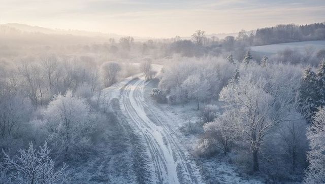 Frosted Valley Dawn Winding Snow Track with Parallel Tire Ruts and Morning Mist