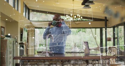 Senior man engaged with digital technology at modern kitchen island