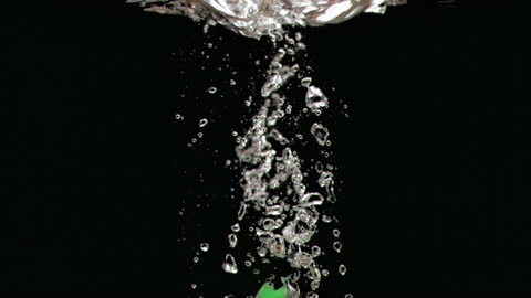 Dartboards Creating Splash in Water Against Black Backdrop