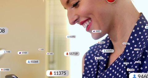 Smiling woman checking smartphone with social notifications and alerts, polka dot blouse