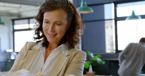 Smiling businesswoman analyzing architectural model in office