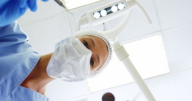 Close-up Dentist Preparing Examination Room with Surgical Light - Download Free Stock Images Pikwizard.com