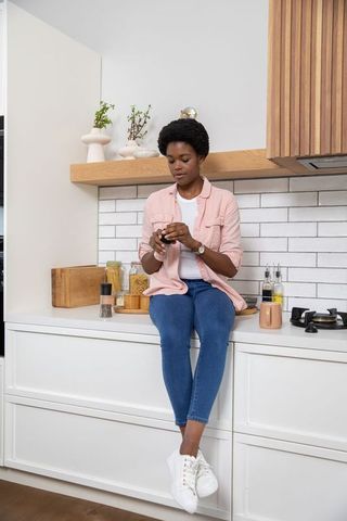 African American Woman Grinding Spices in Modern Home Kitchen