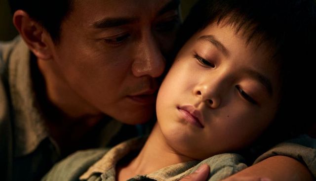 Father holding and comforting son closeup showing tender bond and parental care