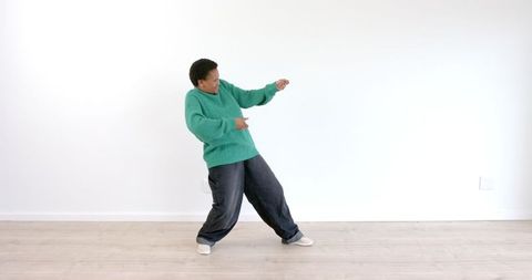 Energetic Person Dancing Joyfully in Green Sweater - Download Free Stock Images Pikwizard.com