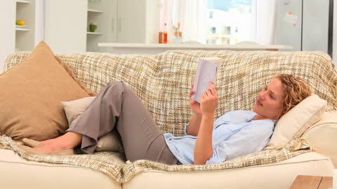 Relaxed Woman Lounging on Sofa Enjoying a Book