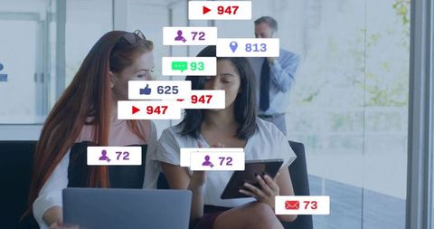 Two businesswomen collaborating over tablet and laptop with social media metrics overlay