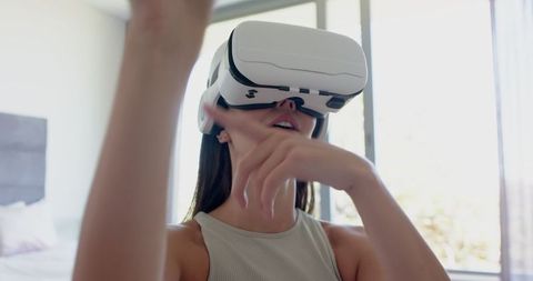 Teen Girl Uses VR Headset for Interactive Experience at Home