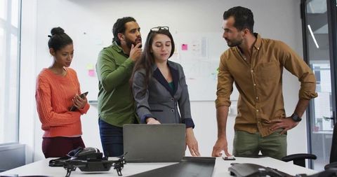 Diverse team collaborating on tech project with drone prototype