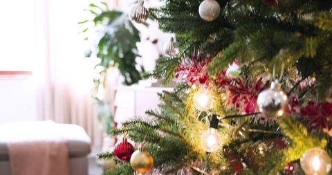 Cozy christmas tree with illuminating baubles in living room