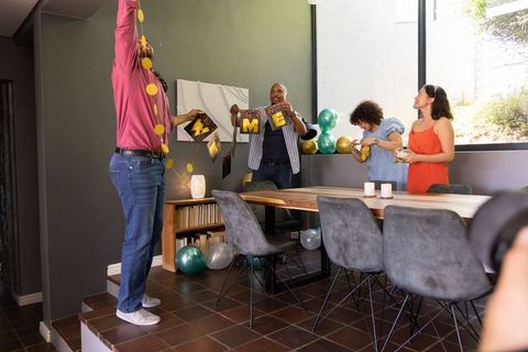 Friends decorating dining room for a festive celebration with balloons