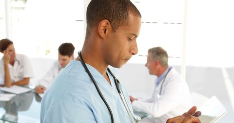 Male Nurse Reviewing Patient File in Hospital Meeting - Download Free Stock Images Pikwizard.com