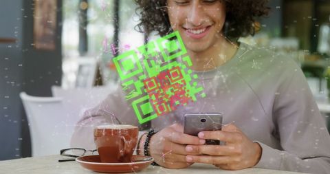 Young man using smartphone to scan qr code at café