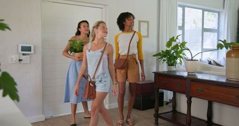 Friendly Diverse Women Exploring Bright Living Space with Plants