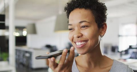 Smiling Businesswoman Making Call in Modern Office Environment