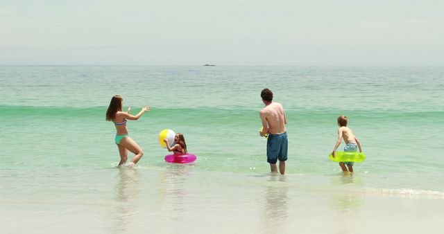 Family Having Fun Playing with Beach Ball in Ocean Waves - Download Free Stock Images Pikwizard.com