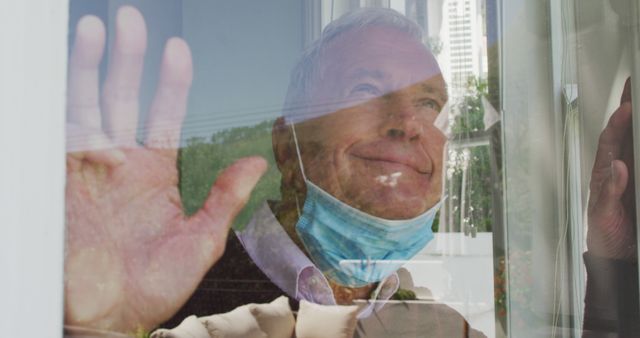 Senior Man Wearing Mask Looking Out Window with Hand Raised - Download Free Stock Images Pikwizard.com