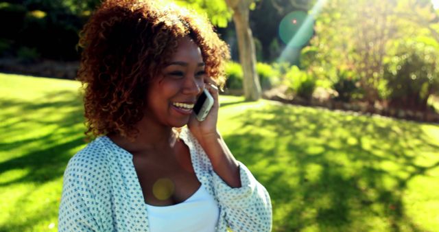 Smiling Young Woman Enjoying Phone Call in Sunny Park - Download Free Stock Images Pikwizard.com