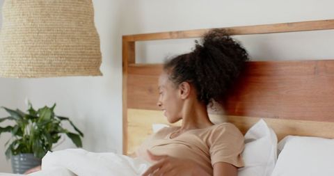 African American Woman Relaxing in Cozy Minimalist Bedroom