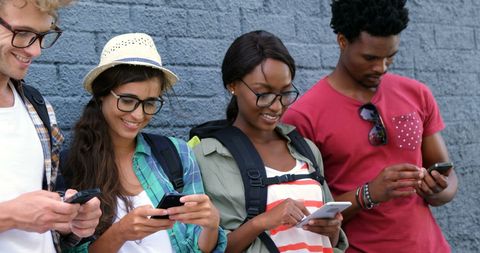 Diverse Young Adults Connected with Smartphones Against Blue Wall - Download Free Stock Images Pikwizard.com