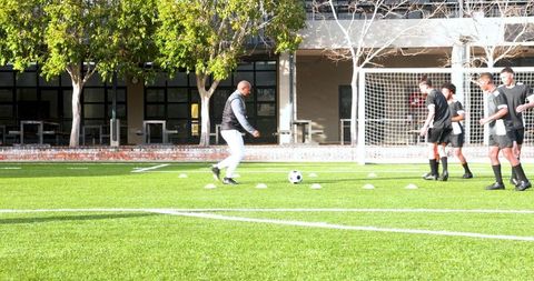 Soccer coach training young players in dribbling skills session