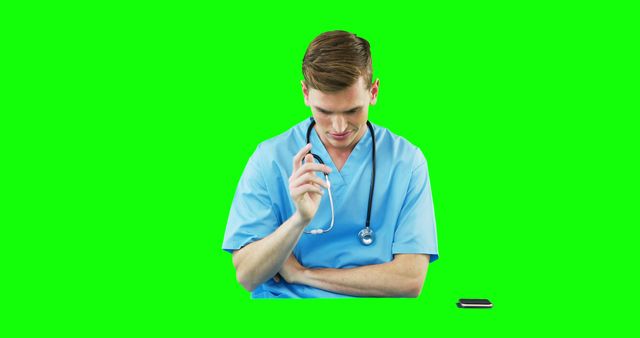 Young Doctor in Blue Scrubs Thinking with Stethoscope and Mobile Phone - Download Free Stock Images Pikwizard.com