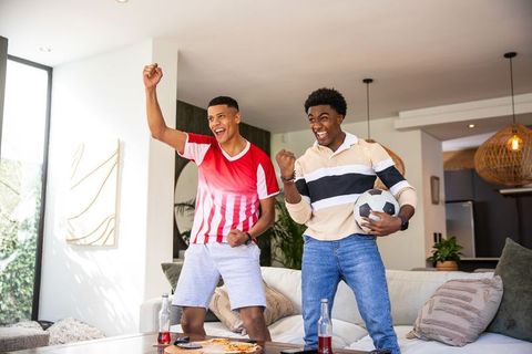 Diverse Friends Cheering Soccer Game at Home with Passion and Joy