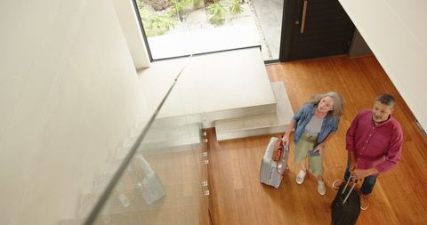 Senior Mother and Son Ready for Travel with Suitcases