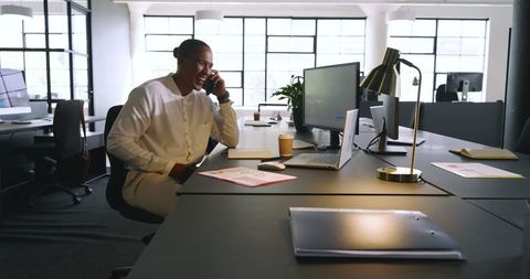 Businessman Engaged in Office Phone Call Reviewing Financial Charts