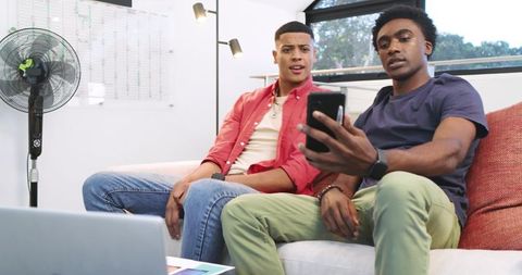 Dynamic duo showcasing smartphone in modern lounge