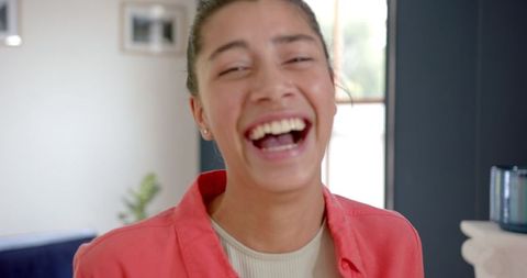 Joyful teen girl laughing at home in bright summer attire