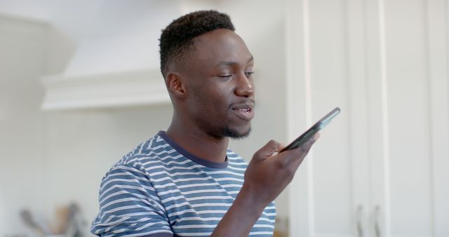 Young Man Speaking into Smartphone in Modern Kitchen - Download Free Stock Images Pikwizard.com