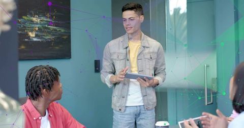 Young Presenter Leading Team Collaboration with Tablet in Modern Teal Office